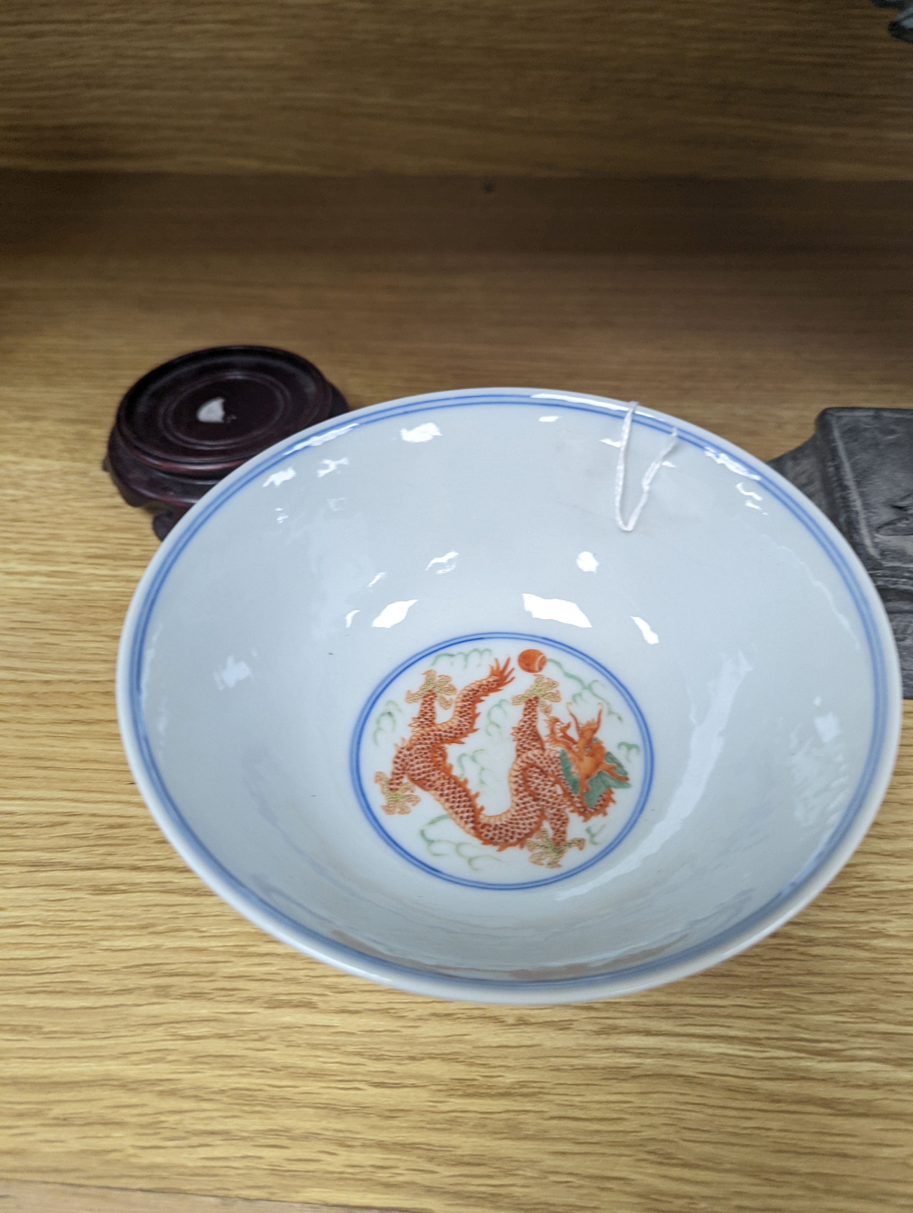 A Wucai bowl, dragon and flamingo pearl decoration, Jiaqing mark, on wood stand. 16cm diameter
